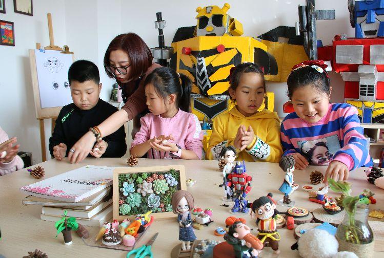 志愿者在介子路社區(qū)教孩子們做手工。  本報記者  盤小美  攝  