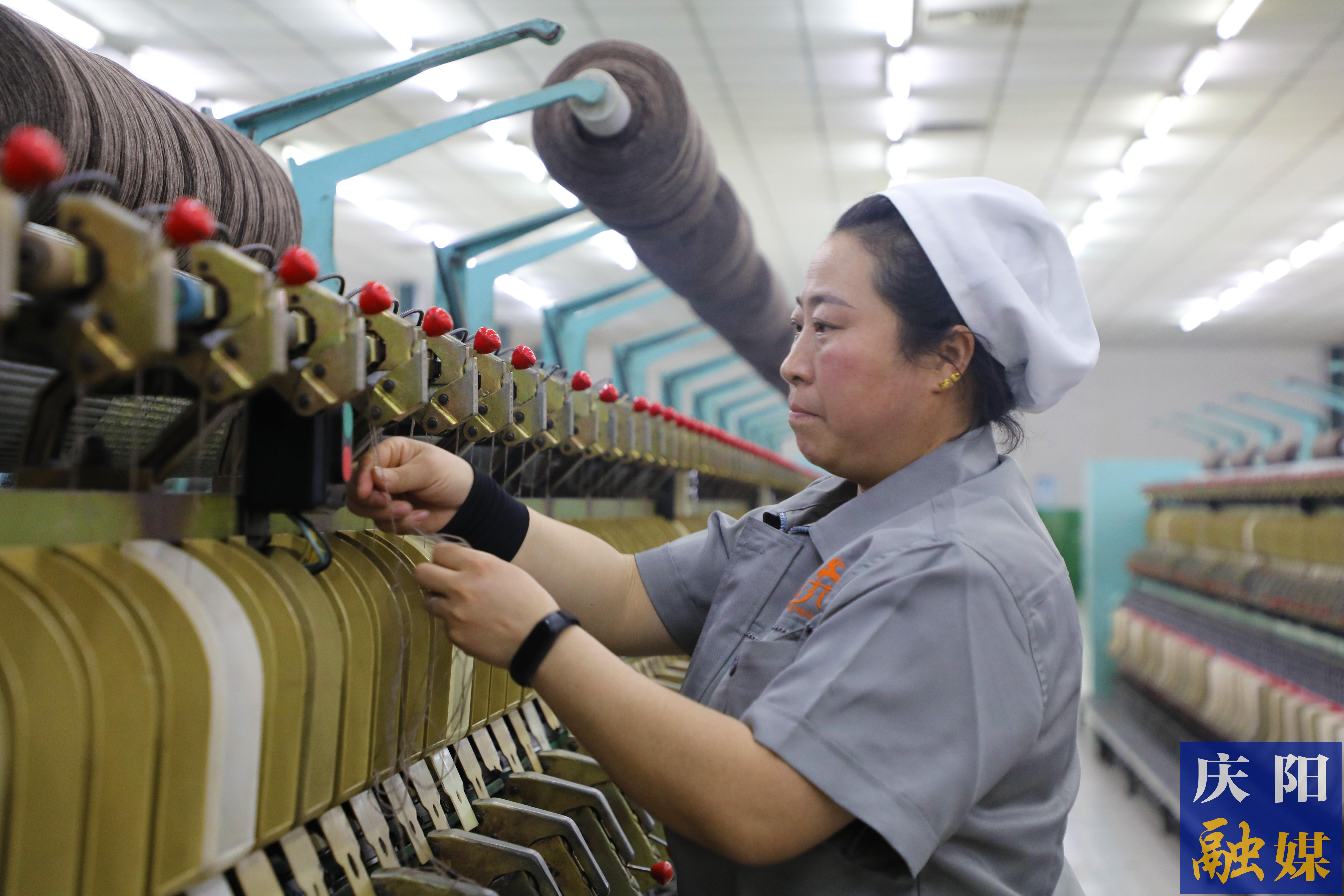 在鎮(zhèn)原縣解語花山羊絨制品有限責(zé)任公司紡紗車間，擋車工龐小麗熟練地操作著機器。 慶陽融媒記者 閆慧 攝